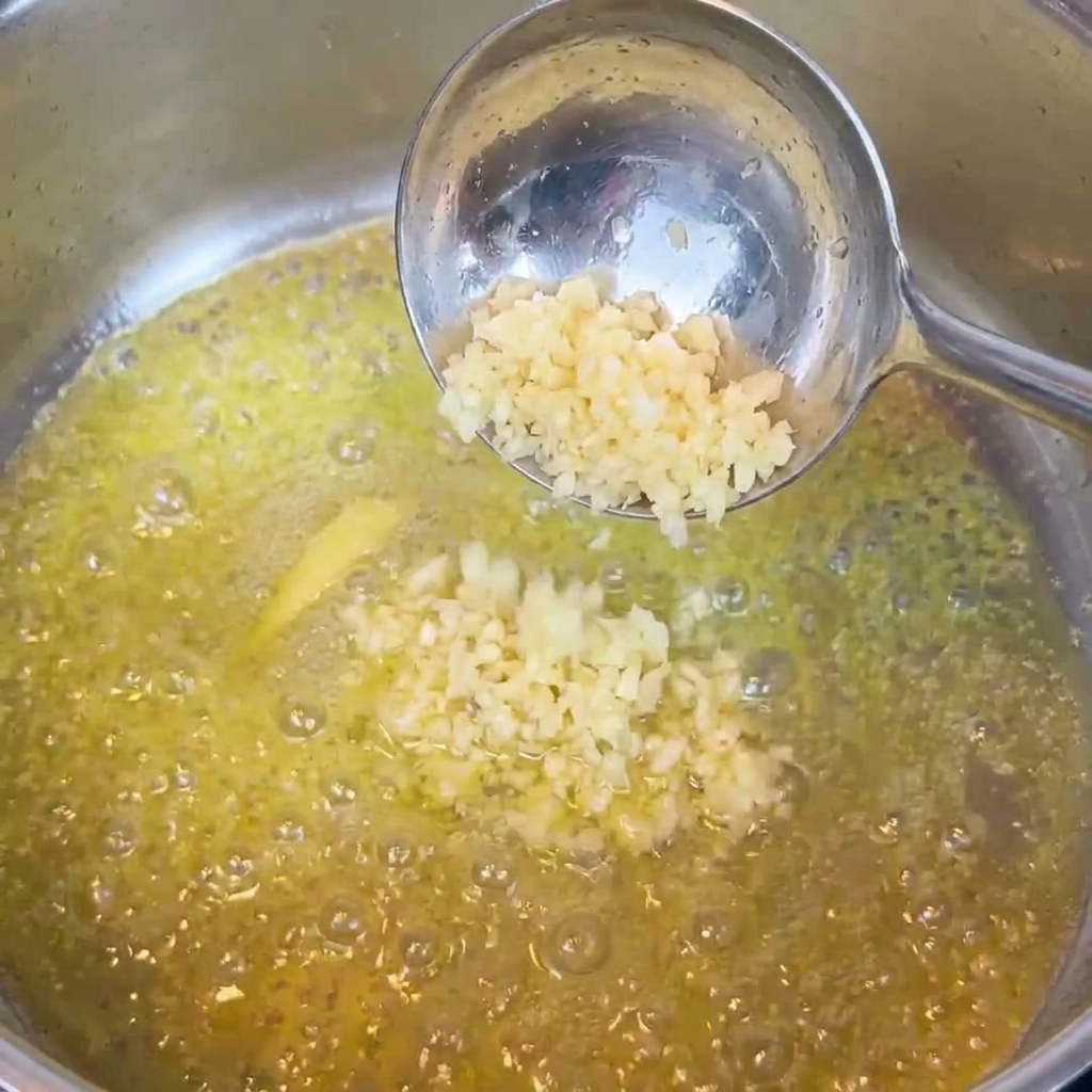 溶けたバターでみじん切りのにんにくを炒める様子