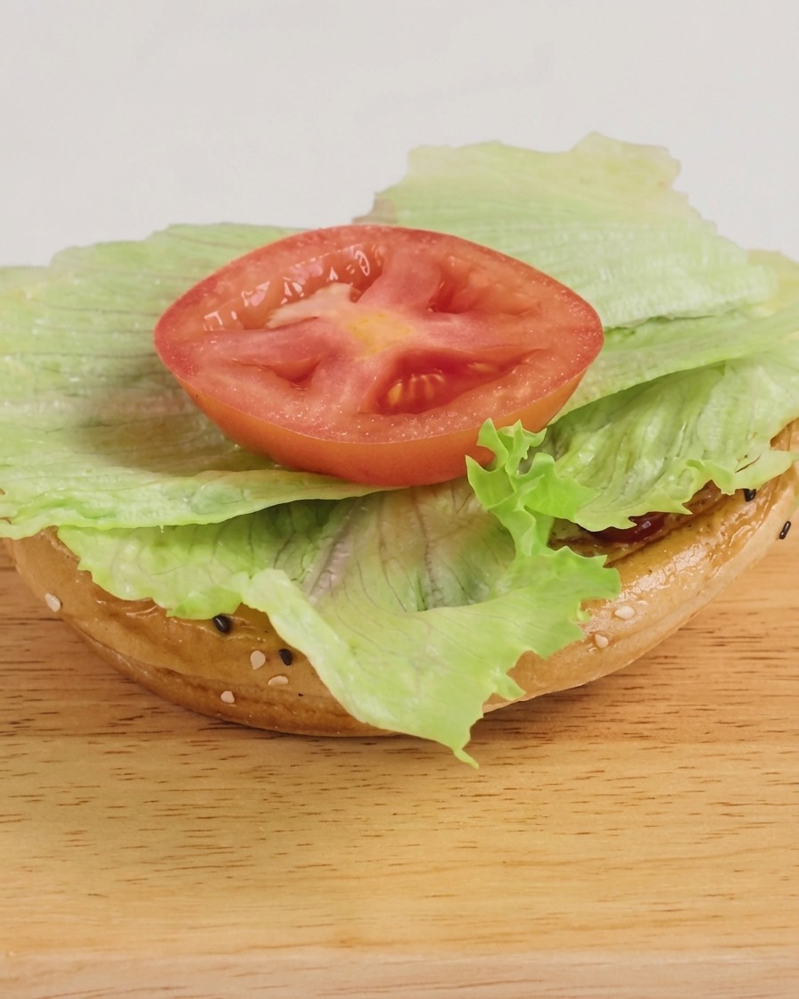 レタス、チーズ付きのビーフパティ、BBQソースがたっぷりのった、完成したばかりのバーガー。