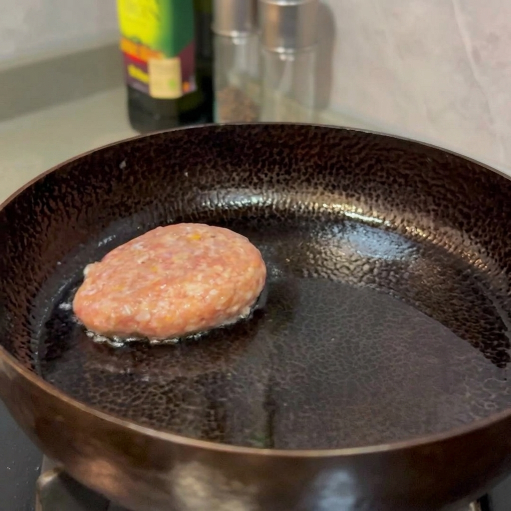 フライパンで焼き色がつくまで焼かれているハンバーグ。