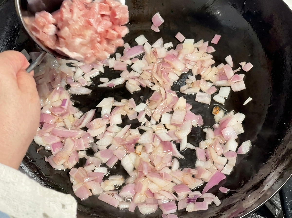 炒めた玉ねぎにひき肉を加えて炒めている様子。