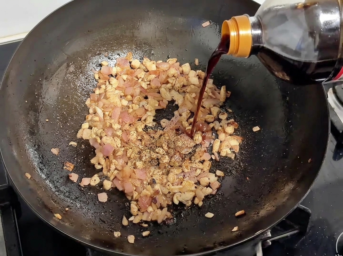 醤油を加え、胡椒を振っている様子。