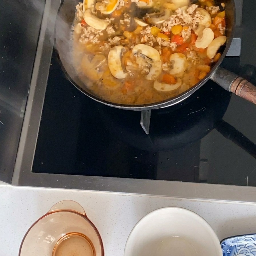 肉ときのこのソースを煮詰めている様子。