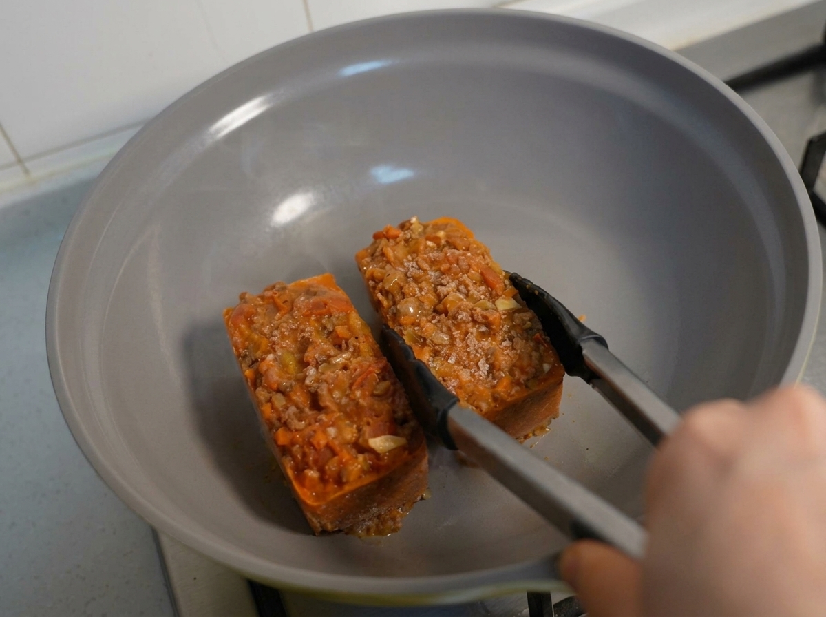 冷凍したパスタとソースの塊をフライパンで温めている様子。