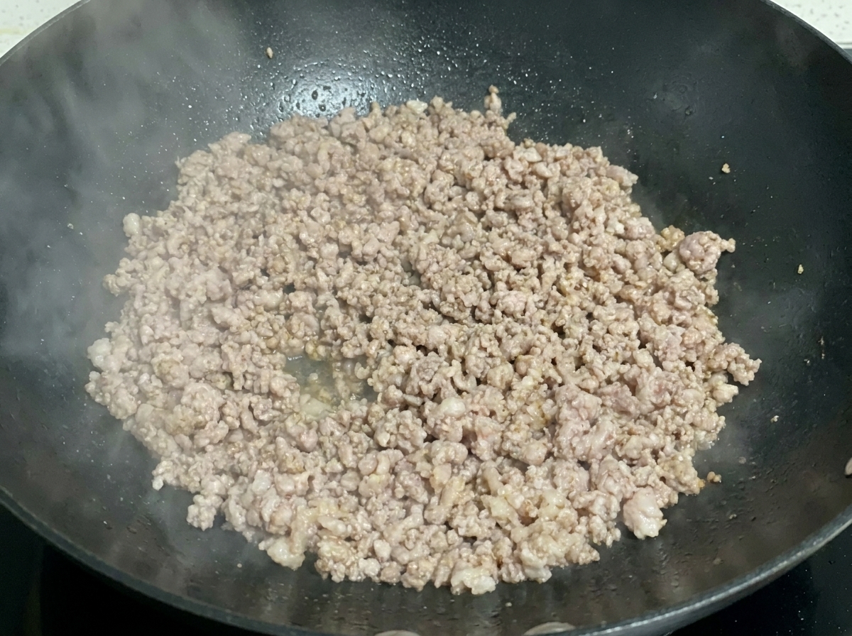 フライパンでひき肉が香ばしく焼けている様子。