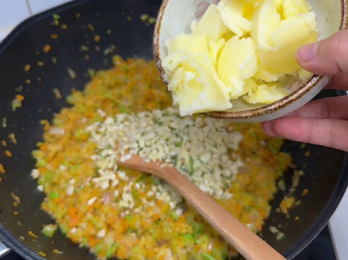野菜にバターとにんにくを加えて炒めている様子。