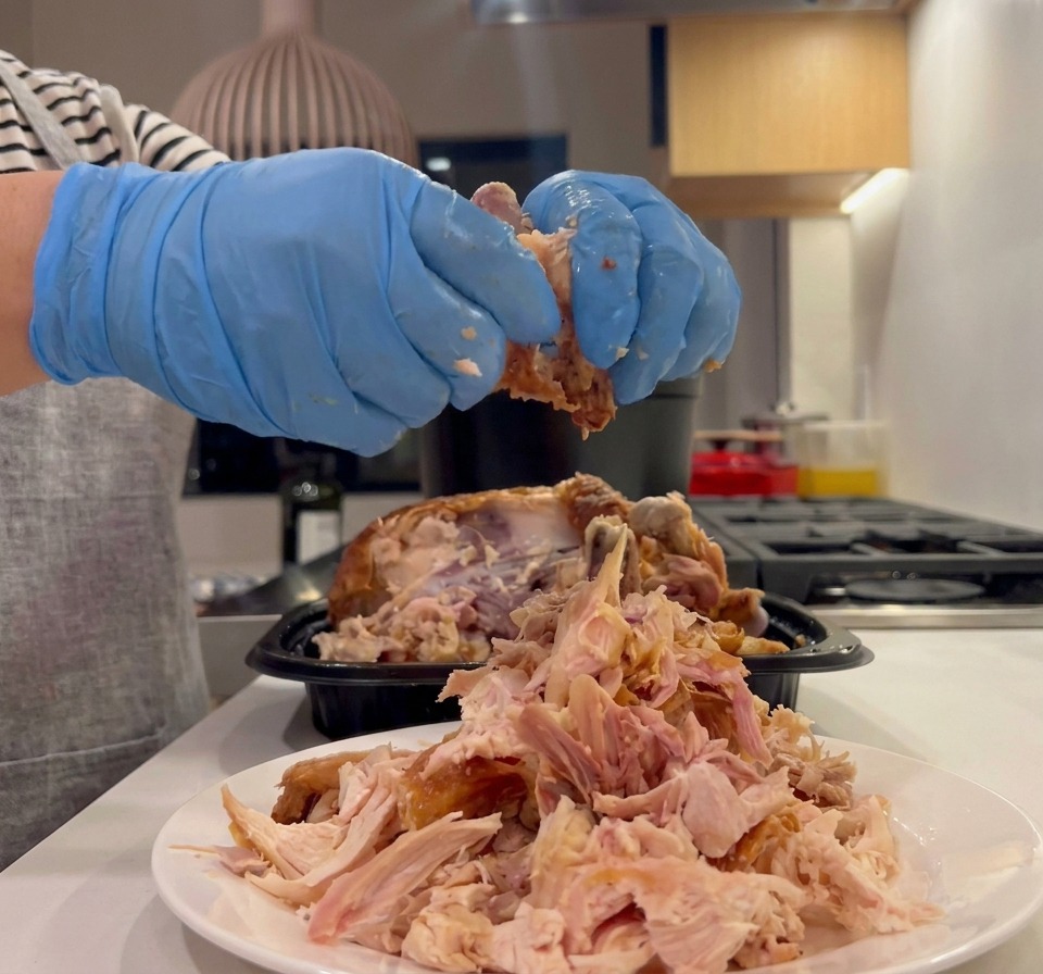 鶏肉を手でほぐしている様子。