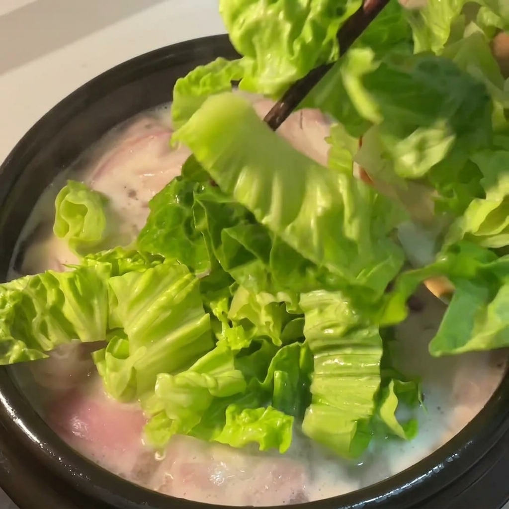 スープにレタスを入れている様子。