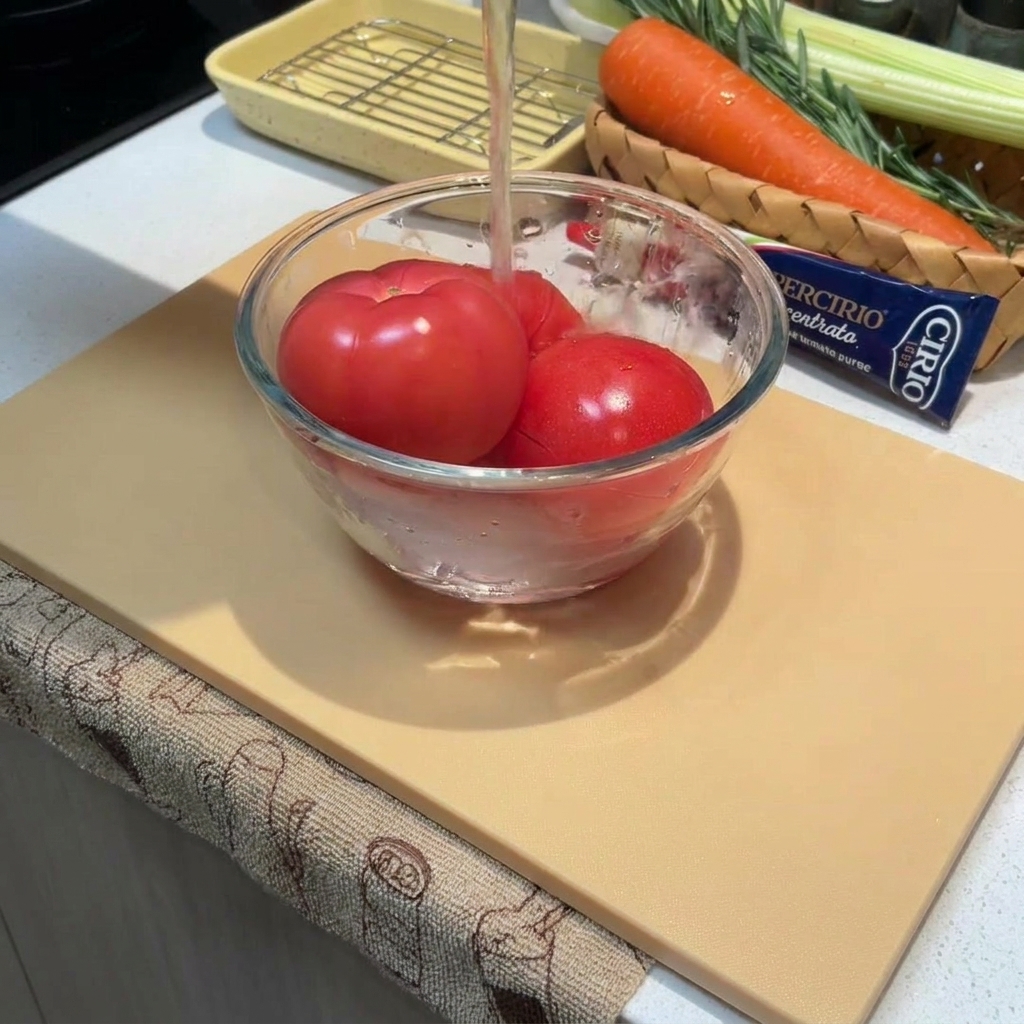 ボウルに入ったトマトに熱湯をかけている様子。