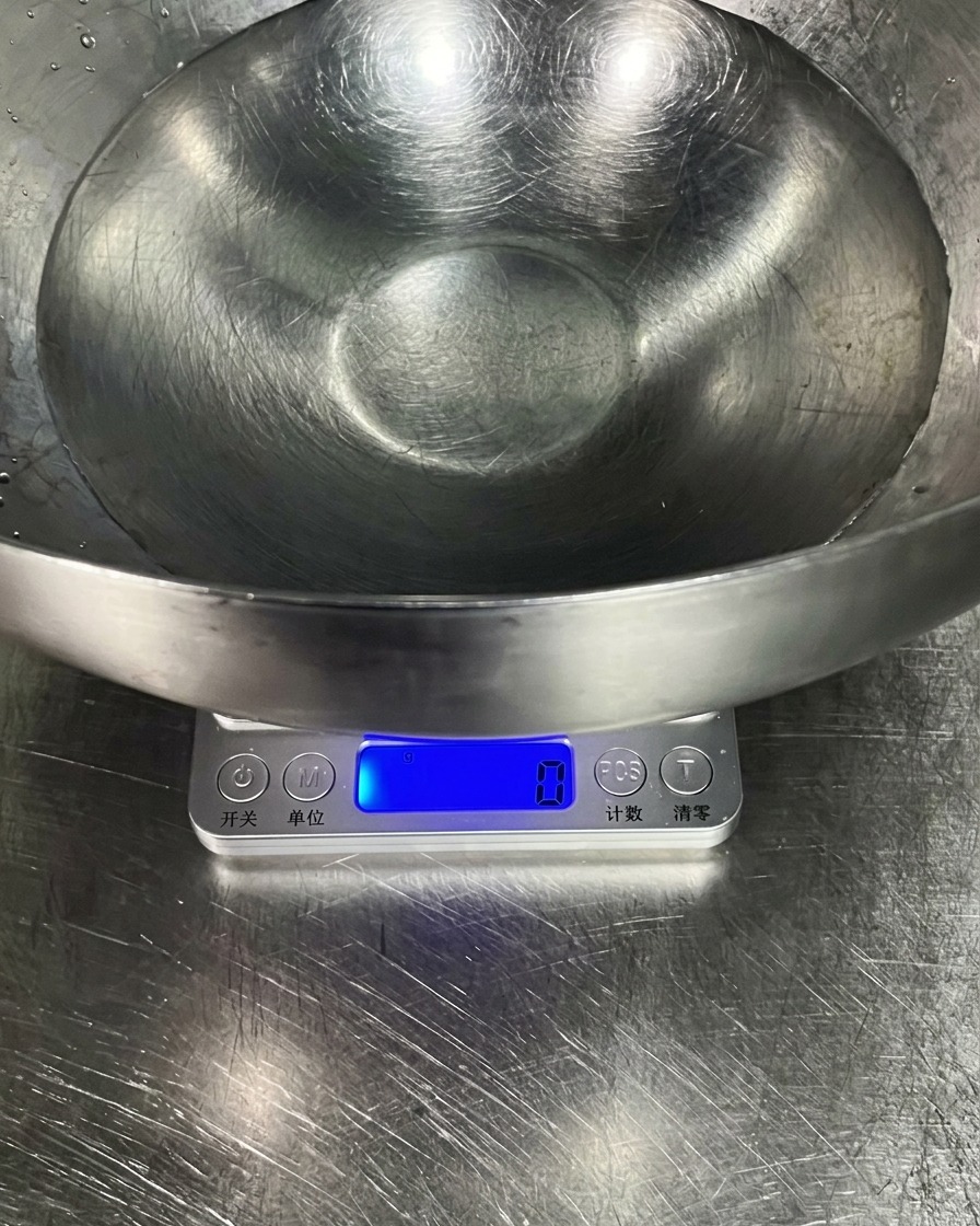 デジタルスケールの上に置かれた、冷水が入った大きなステンレスボウル。