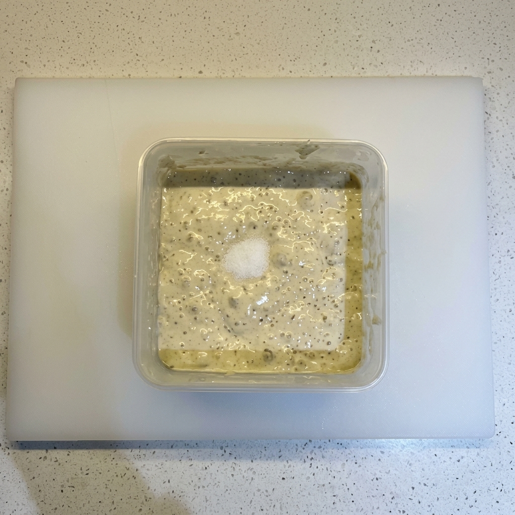 発酵して気泡を含んだ生地の上に、塩と山盛りの小麦粉が乗っている様子。