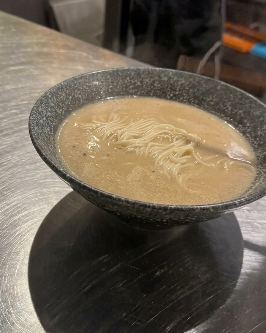 麺の中央に、味付けした挽き肉を盛り付けている様子。