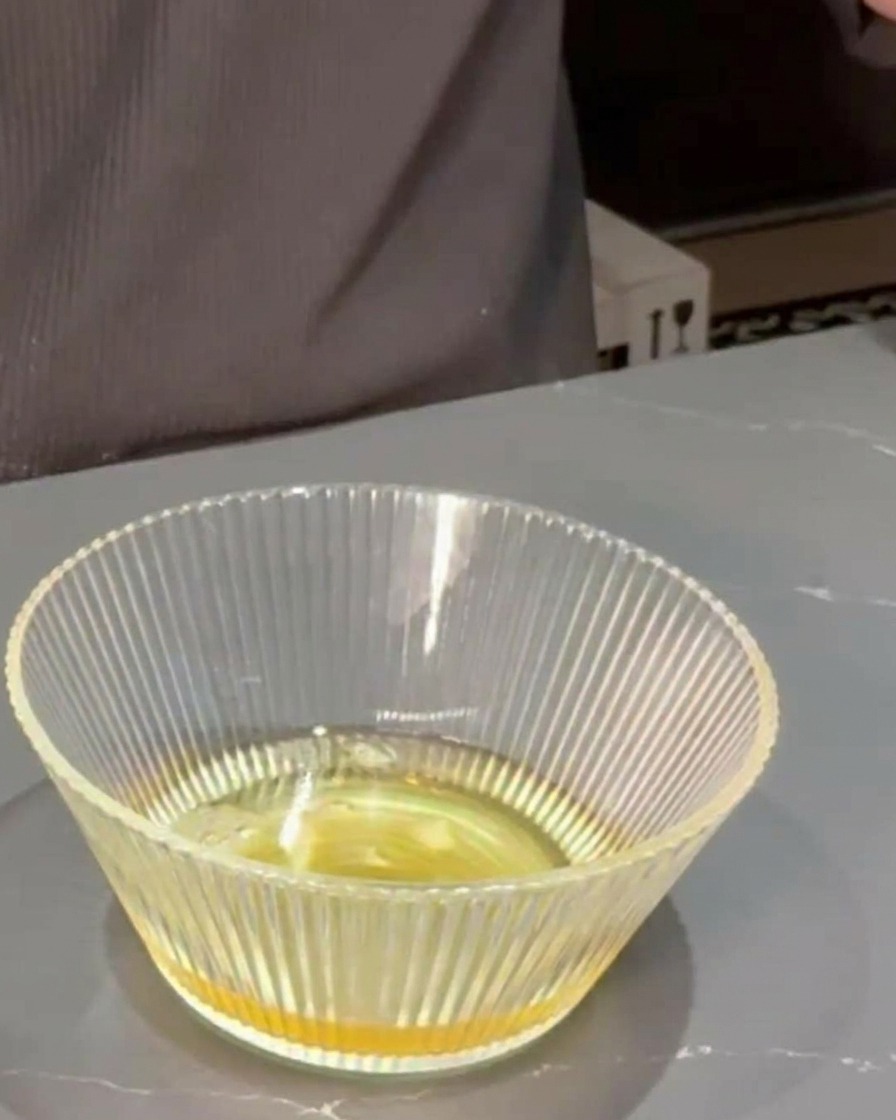 出汁の入ったボウルに、みりんと醤油を加えて混ぜている様子。