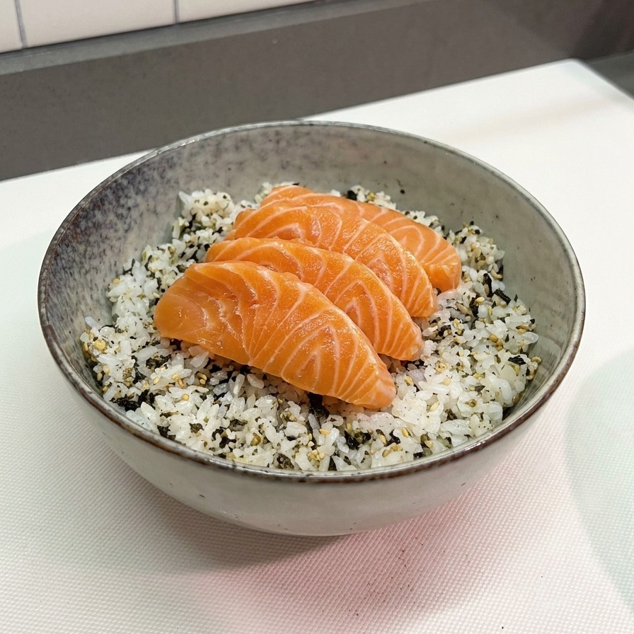 グレーの陶器の丼に盛られた温かいご飯の上に刻みのりを散らし、鮮やかなオレンジ色のサーモンを4切れ綺麗に並べている様子。