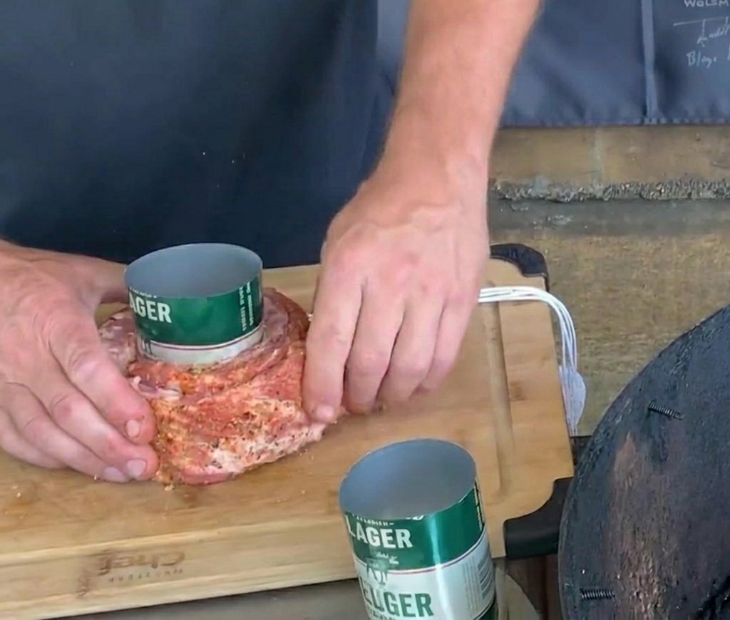 緑色のビール缶に巻きつけた味付きポークリブの真ん中に、白いタコ糸を丁寧に結んでいる手元。