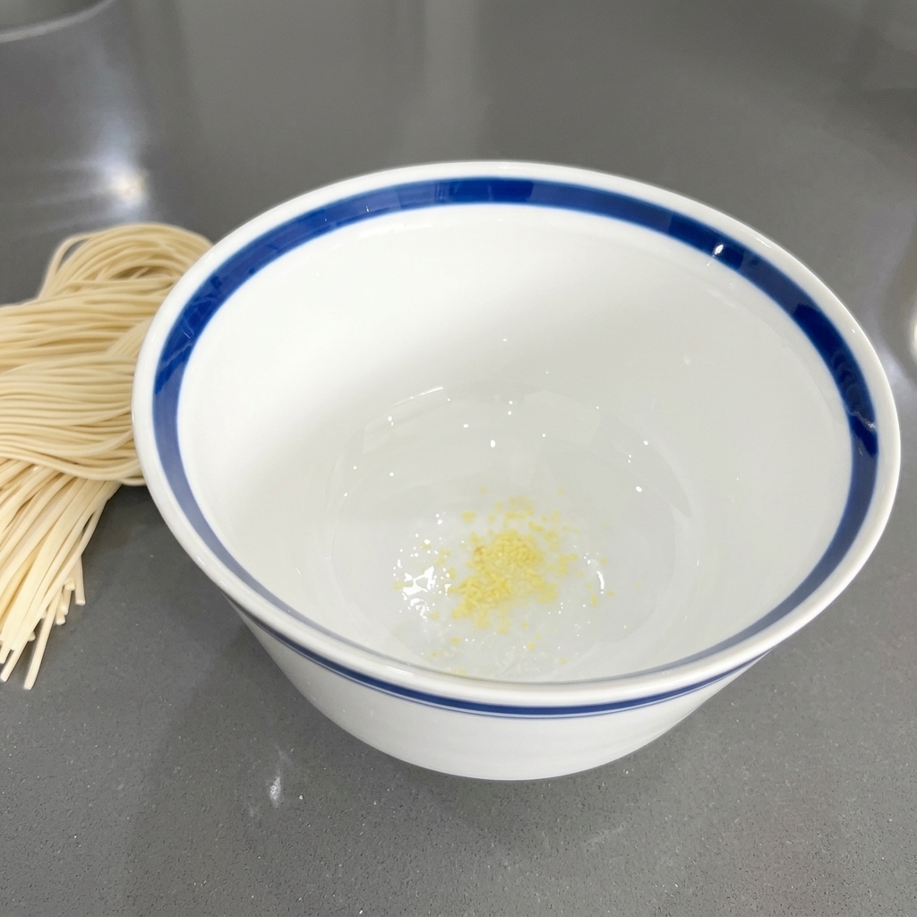 白いどんぶりの底に入っている、少し黄色みがかったみじん切りのにんにく。