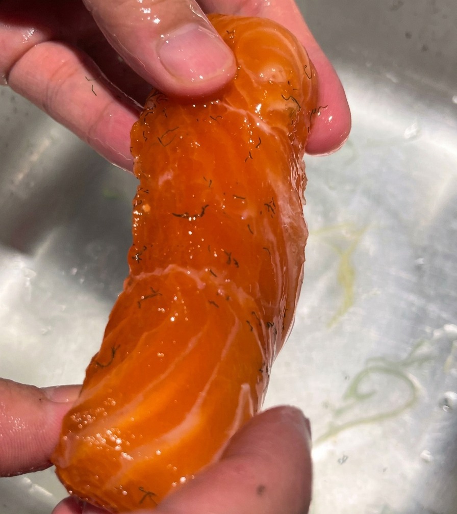 流水でサーモンの塩を洗い流す様子