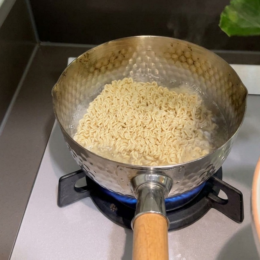 沸騰した鍋で茹でられているインスタント麺の上に、手で新鮮な緑色のほうれん草をのせている様子
