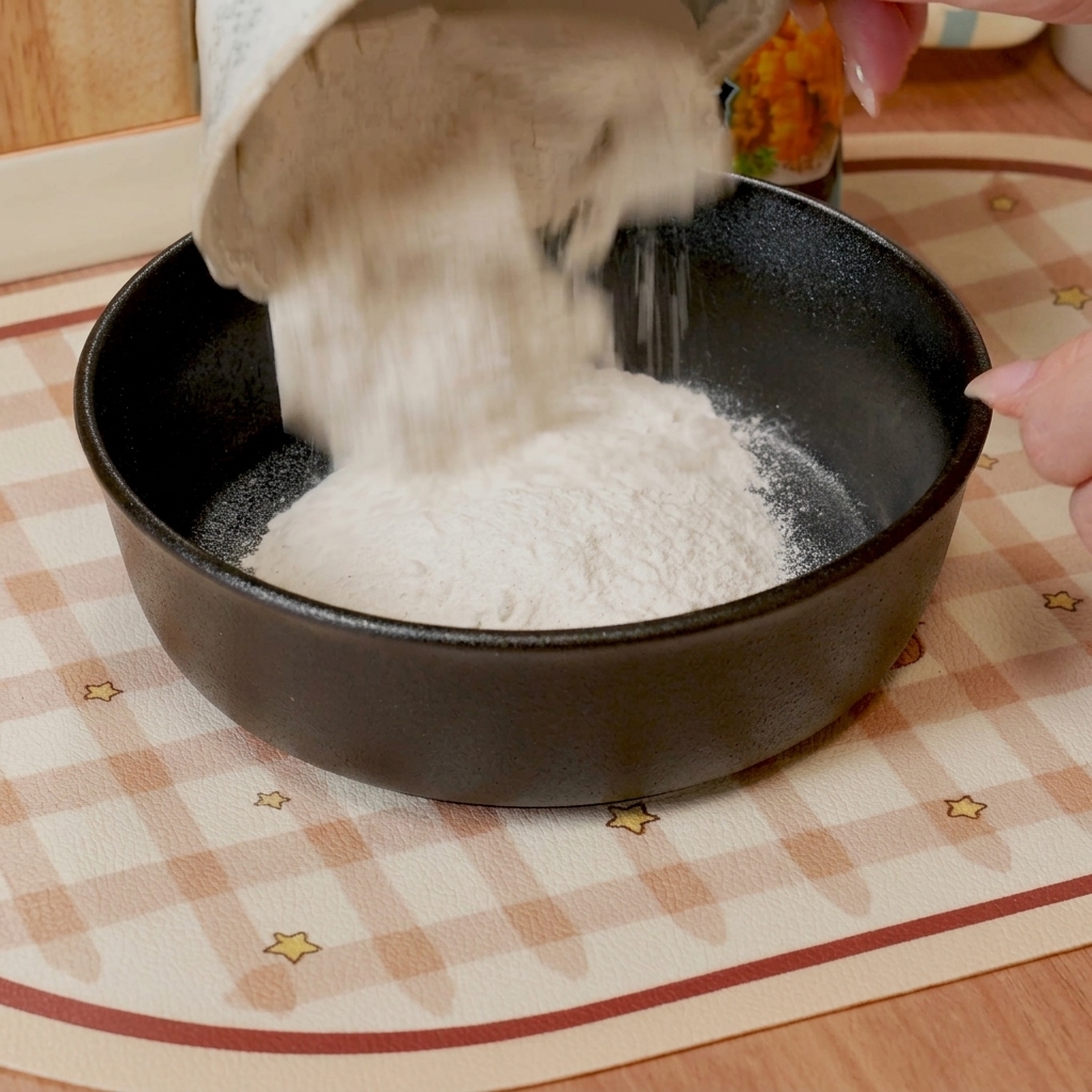 ボウルで天ぷら粉と冷水を混ぜ合わせている様子