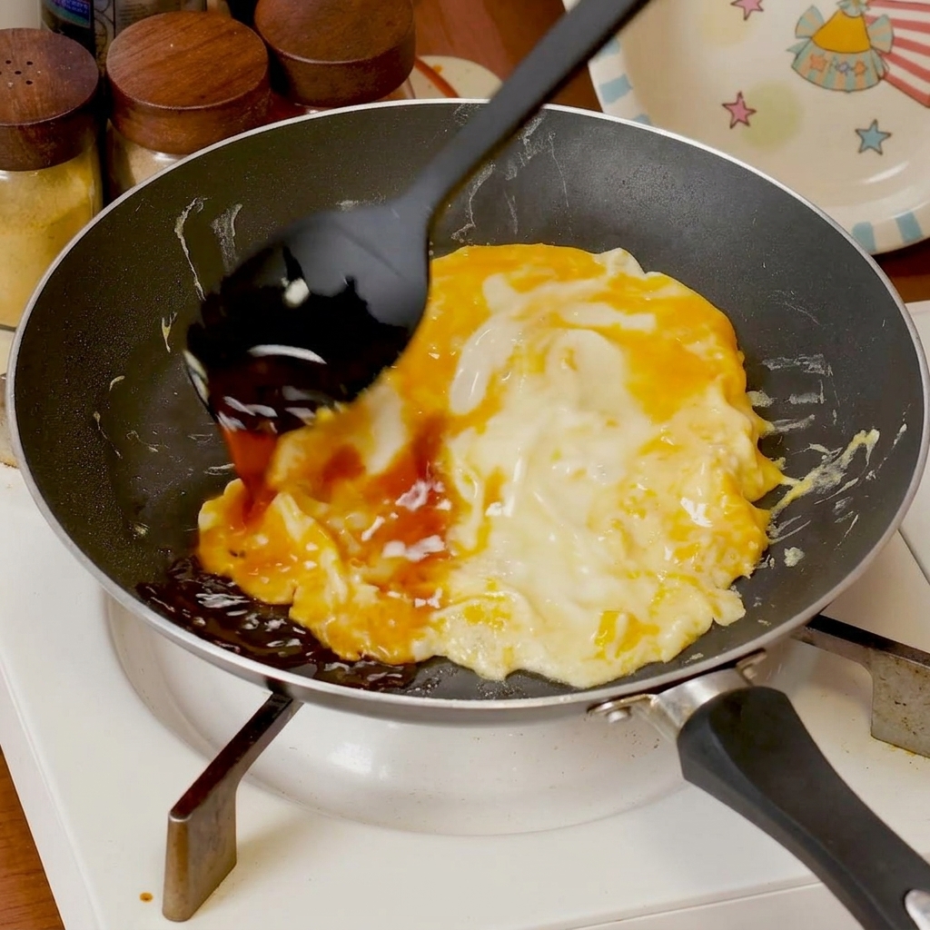 半熟卵に煮汁をかけている様子