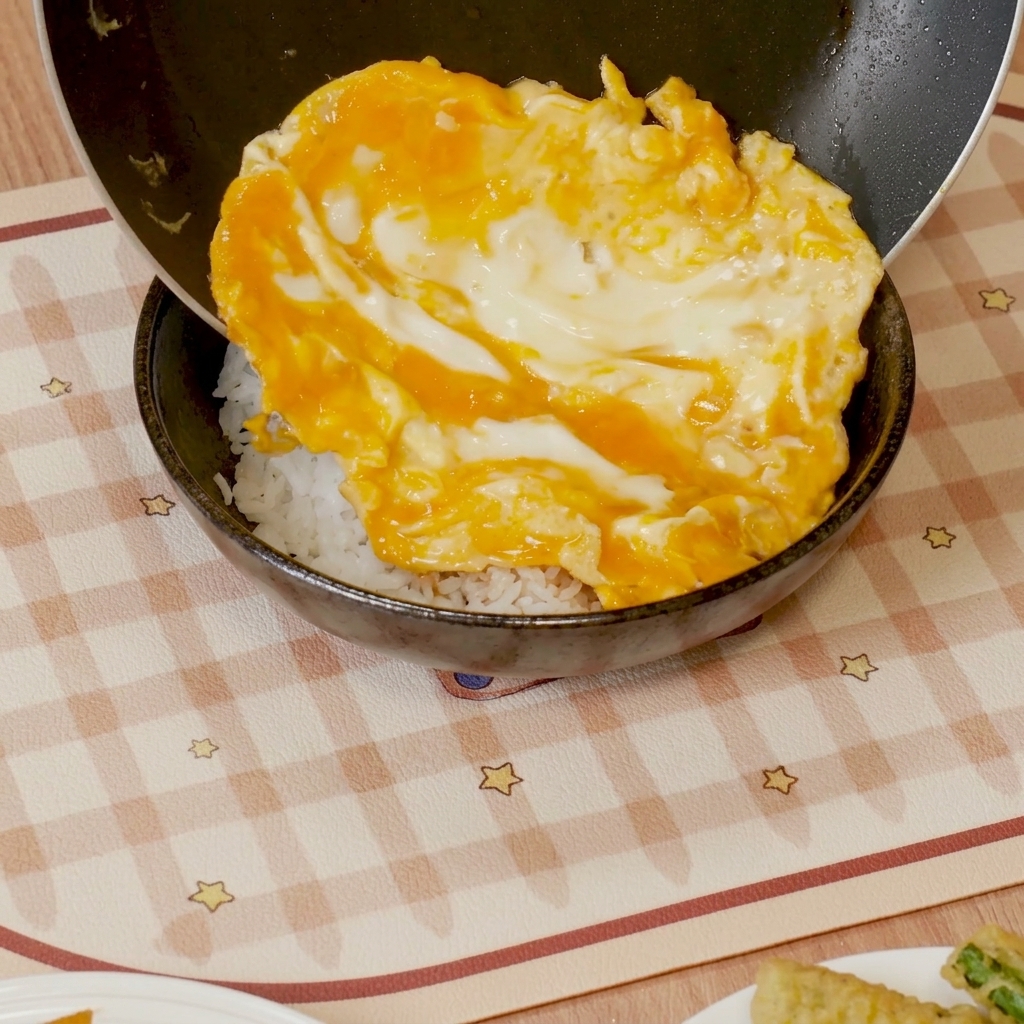 ご飯の上に半熟卵を盛り付けている様子