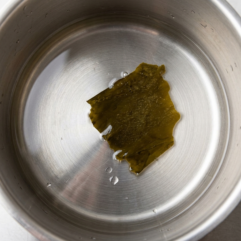 冷水の入った鍋に乾燥昆布を入れ、火にかける様子。