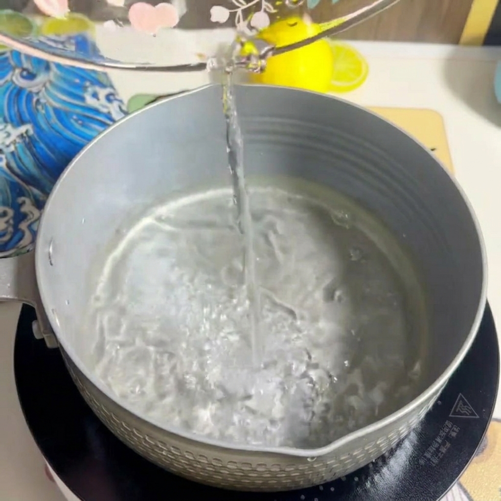 鍋に牛乳が注がれ、水と混ざり合う様子