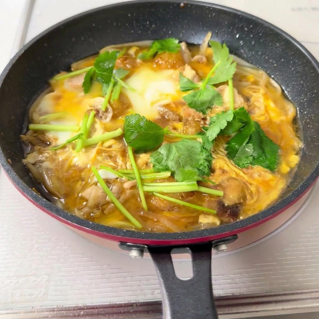 丼のご飯の上に親子丼の具を盛り付けている様子