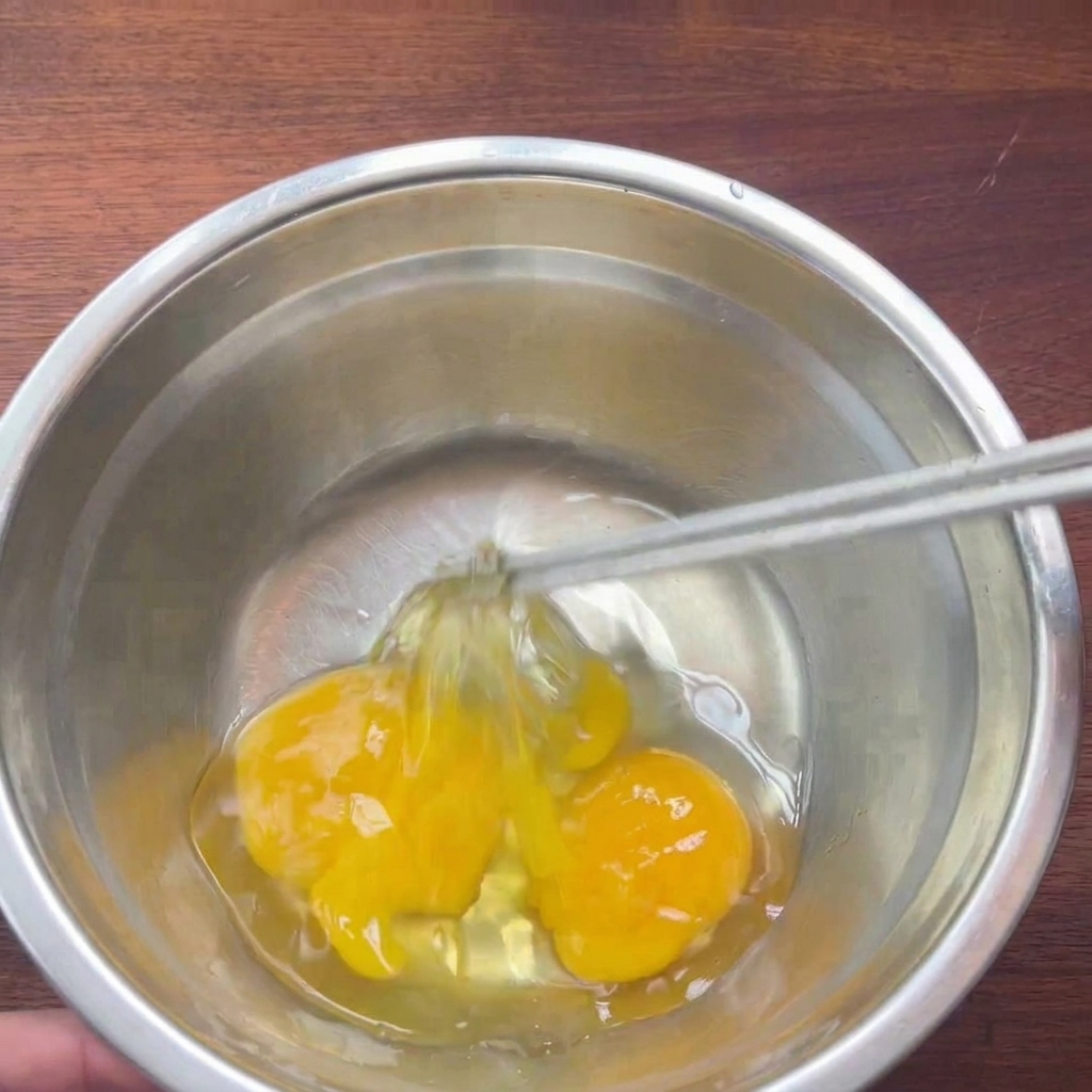 ボウルの中で卵を軽く溶きほぐしている様子