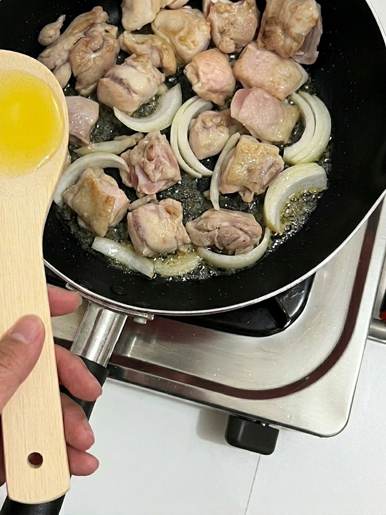 鶏肉と一緒に玉ねぎを炒める様子