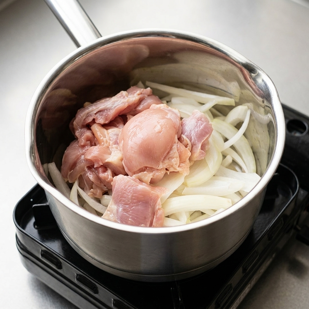 鍋に入った玉ねぎと鶏肉に、醤油やみりんなどの調味料を加えている様子。