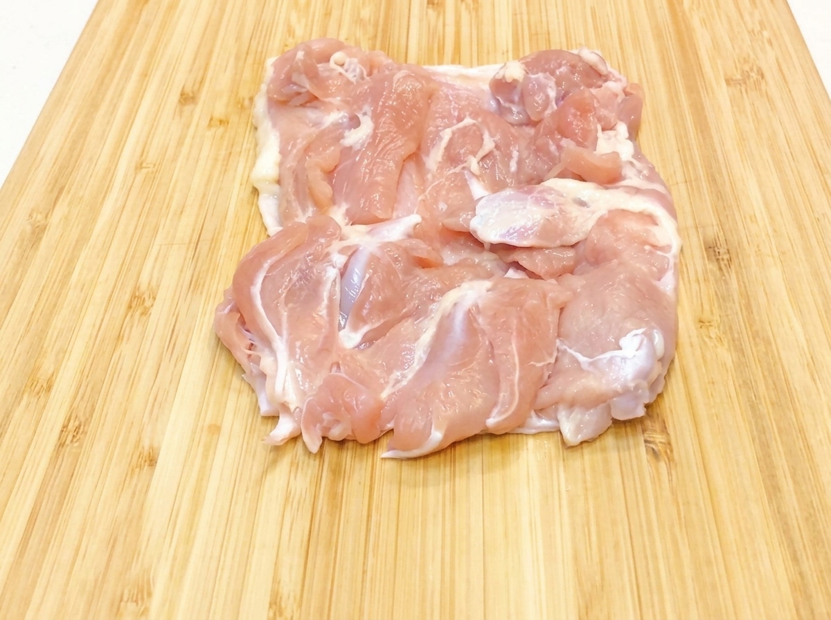 予熱した黒いフライパンにサラダ油を注いでいる様子。