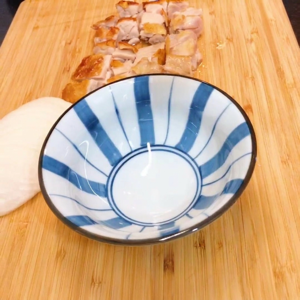 青と白のストライプ模様のボウルで、みりんと醤油を混ぜ合わせている様子。