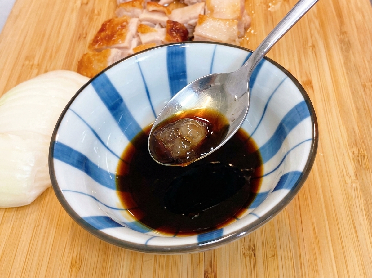 ガスコンロに乗せた小さな金属製のフライパンに、薄切りにした生の玉ねぎが綺麗に盛られている様子。