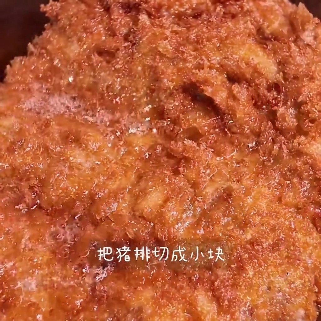 揚げたての豚カツをまな板の上で食べやすい大きさに切っている様子。