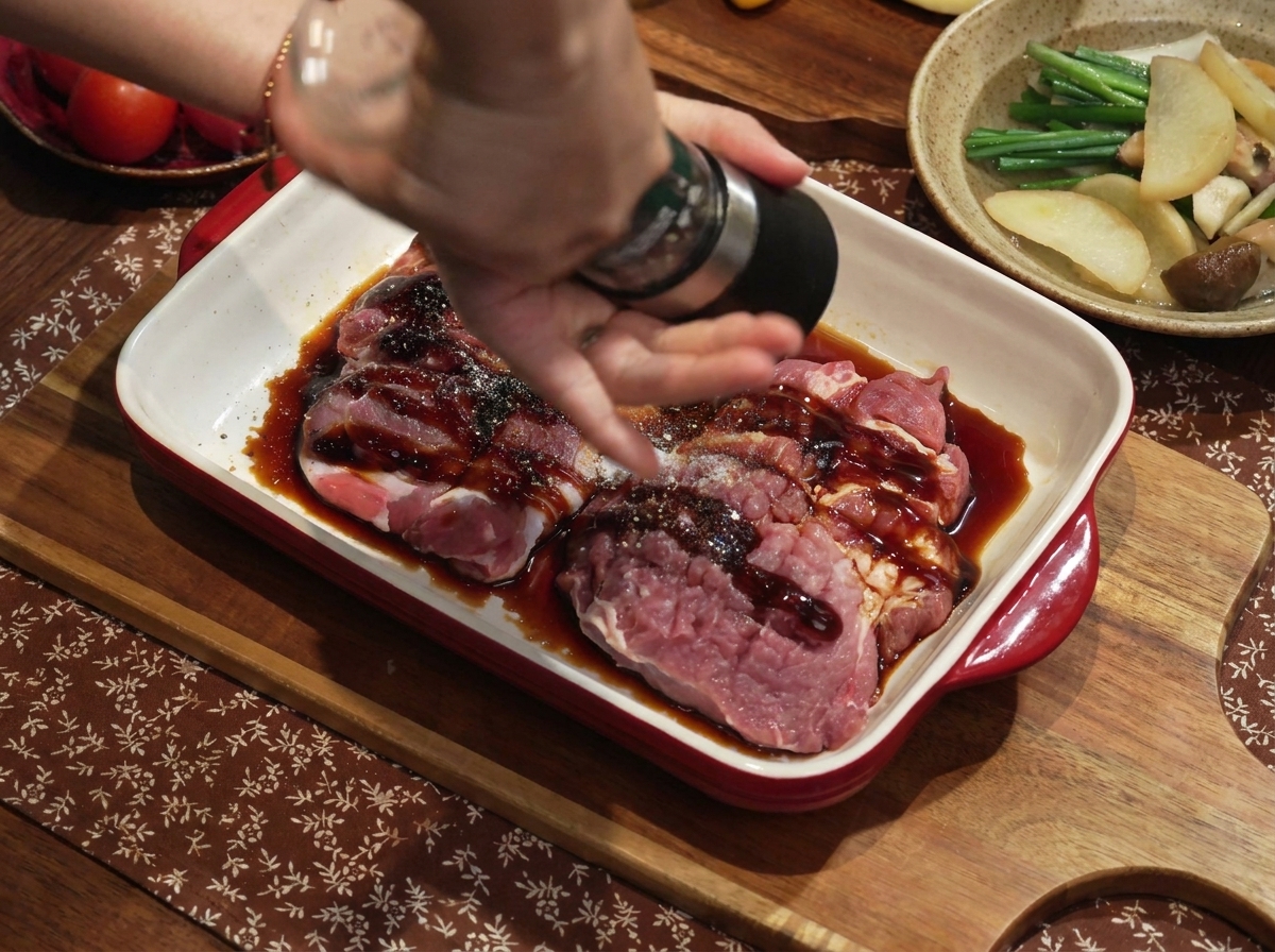 下味をつけた豚肉に、ネギと生姜の水をかけている様子。