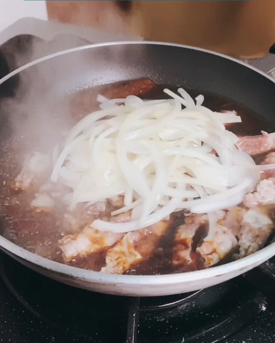 炒めておいた玉ねぎをフライパンに戻し、牛肉と一緒に煮込んでいる様子。