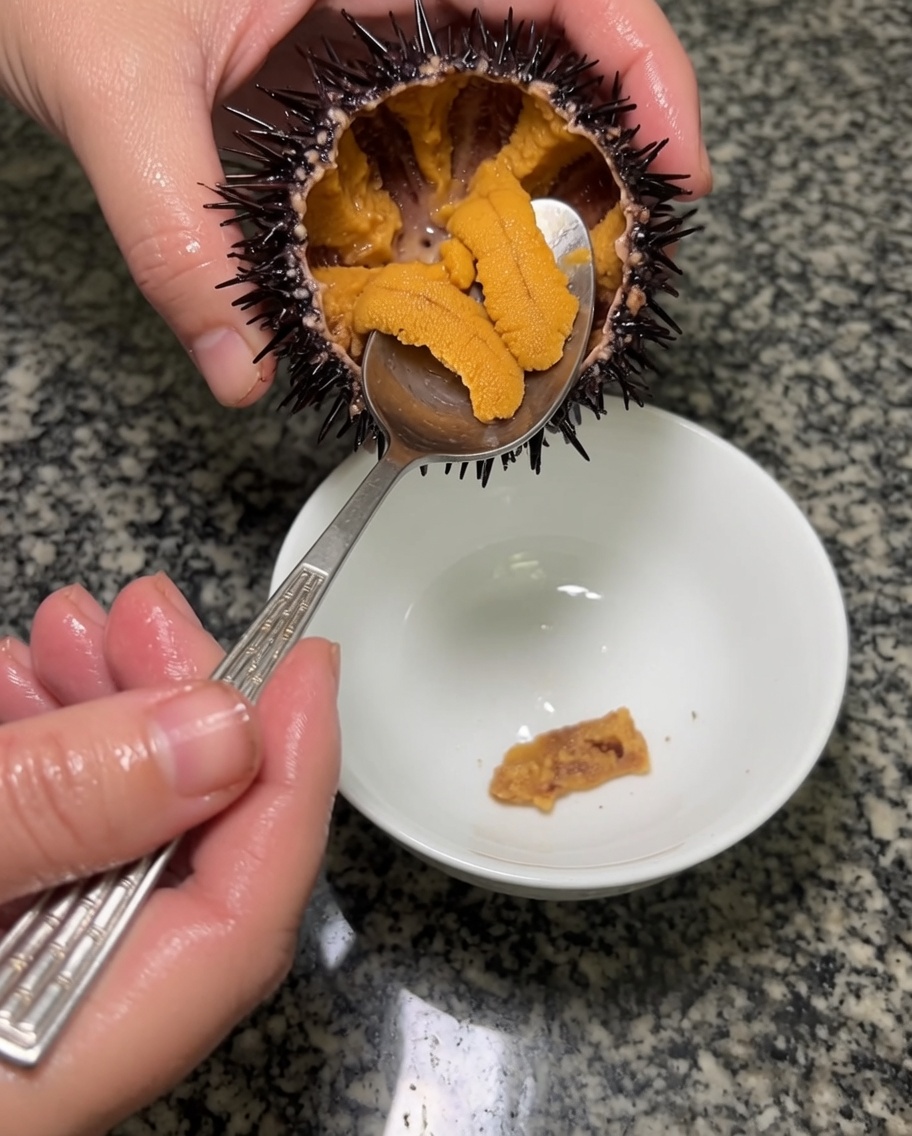 金属のスプーンで雲丹の身をすくい出している様子