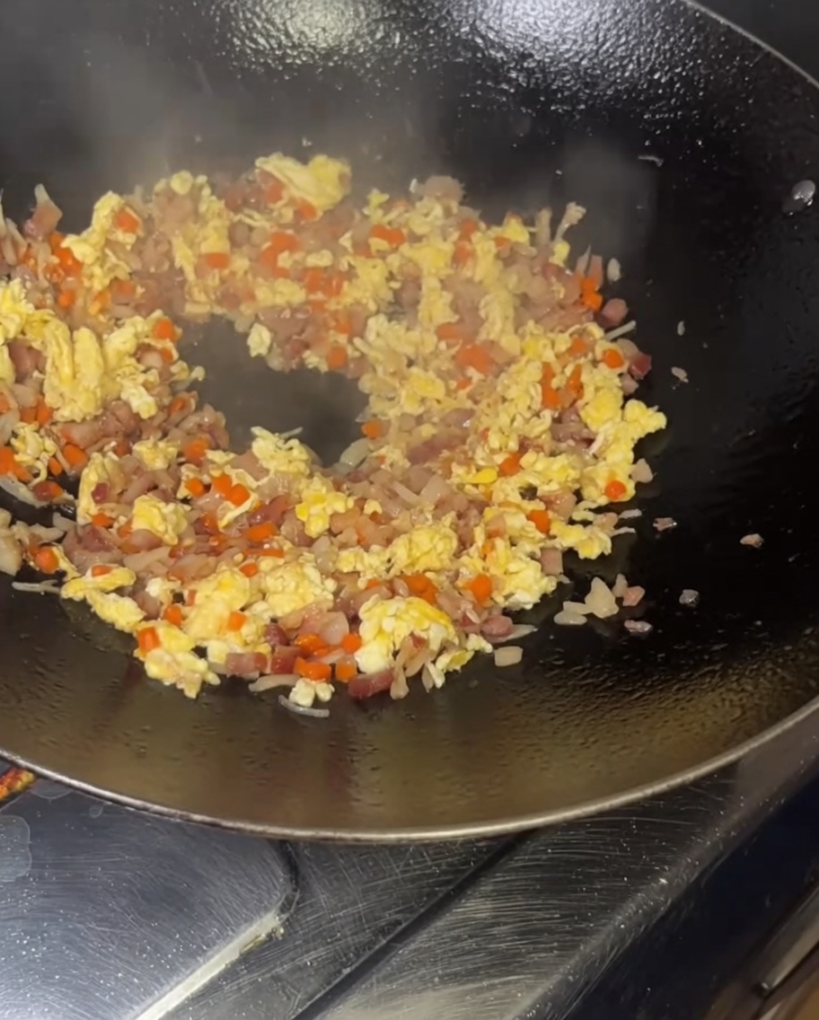 黄金色のご飯を熱い中華鍋に投入している様子