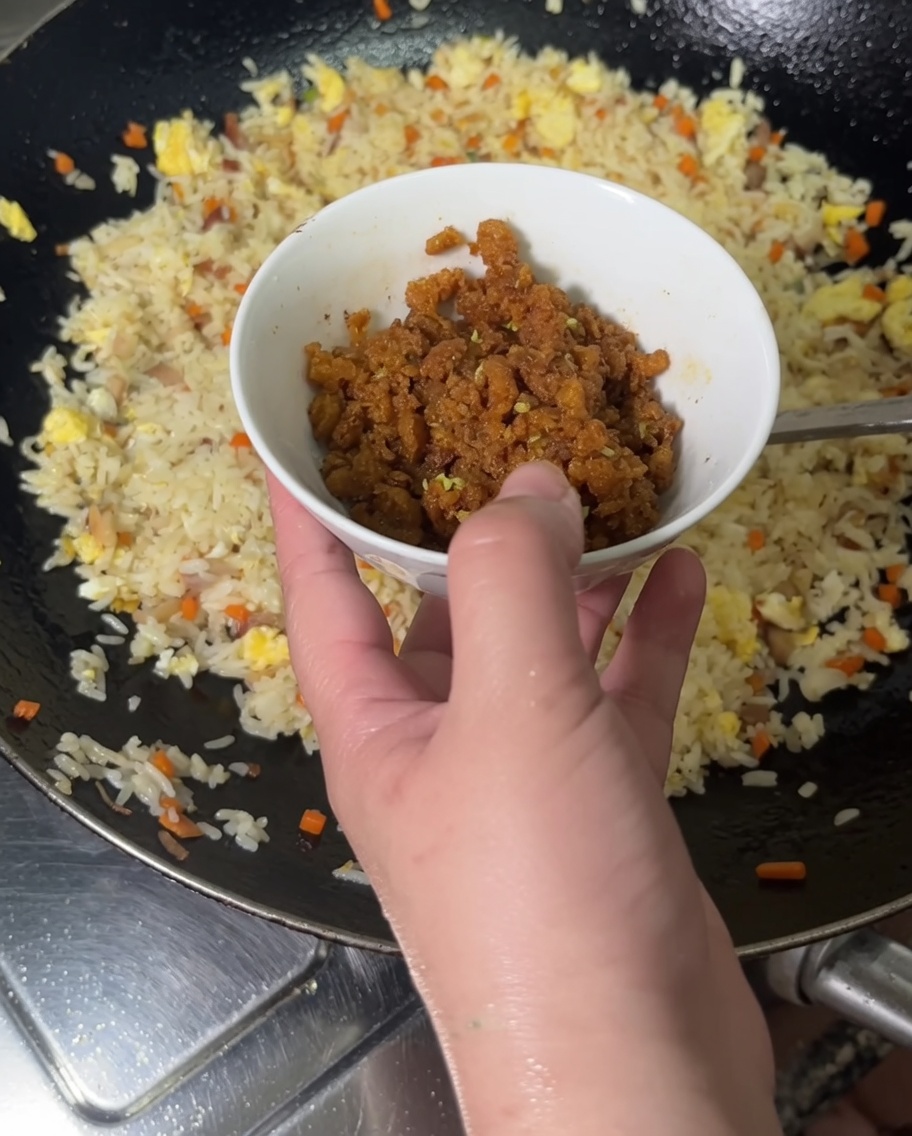 炒めた雲丹をご飯の鍋に加えている様子