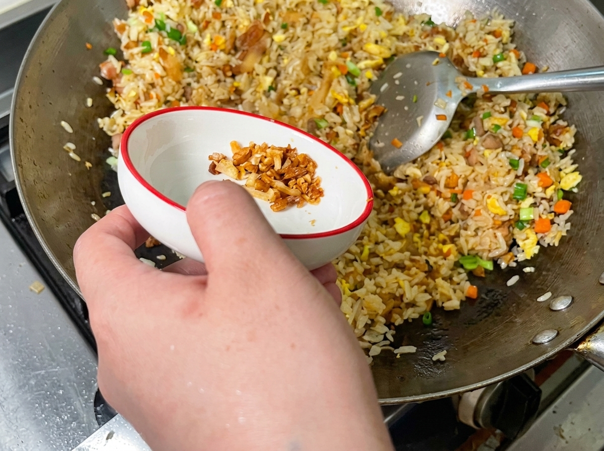 炒飯にカリカリの豚背脂チップをかけている様子