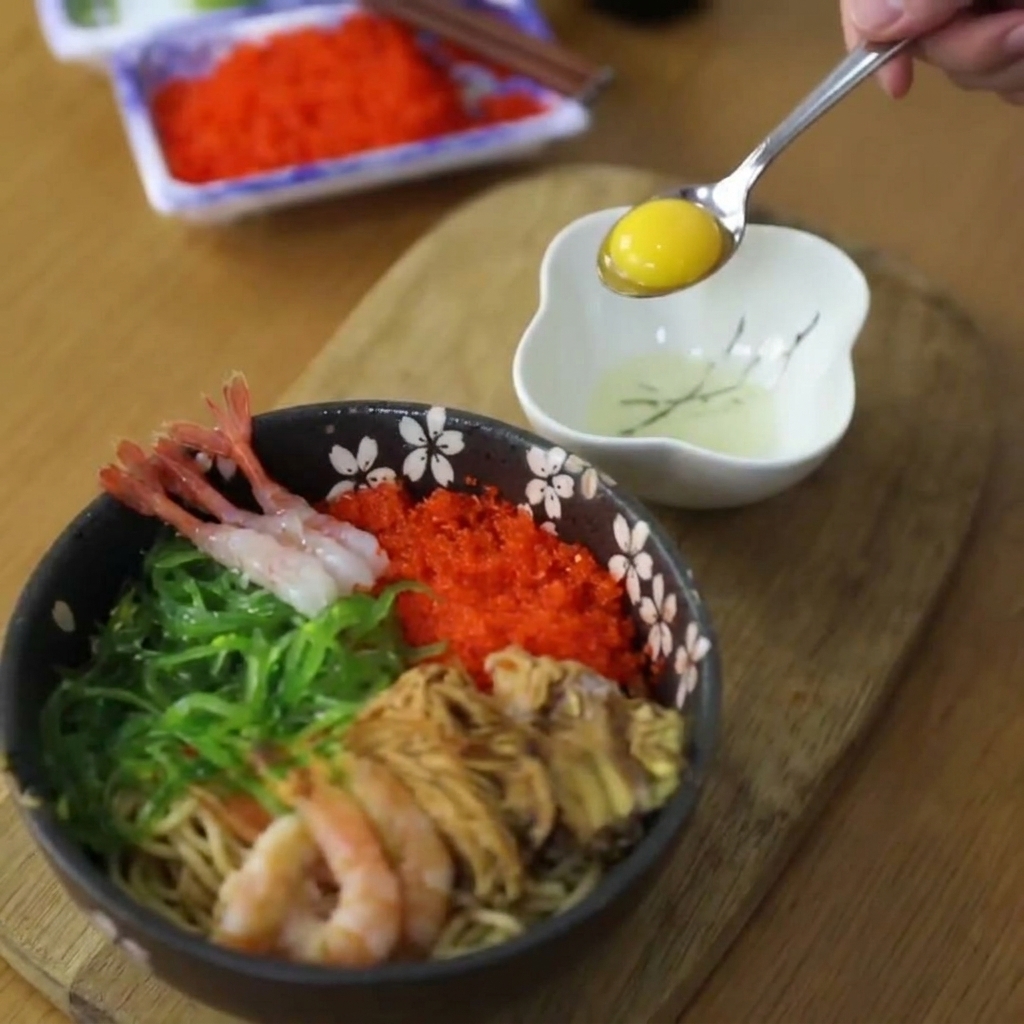 小皿に割ったうずらの卵から、スプーンで黄身だけを慎重にすくい上げている。