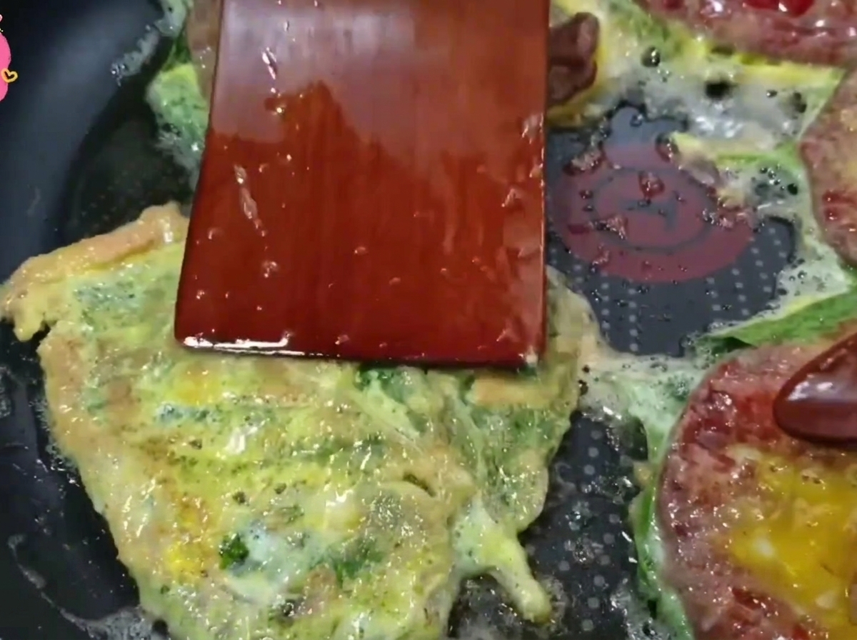フライ返しで黄金色に焼けた牛肉を裏返している様子。