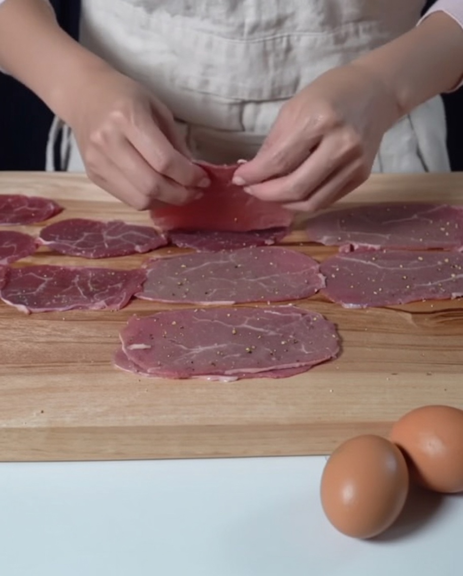まな板の上に並べられた下味前の牛肉スライス。