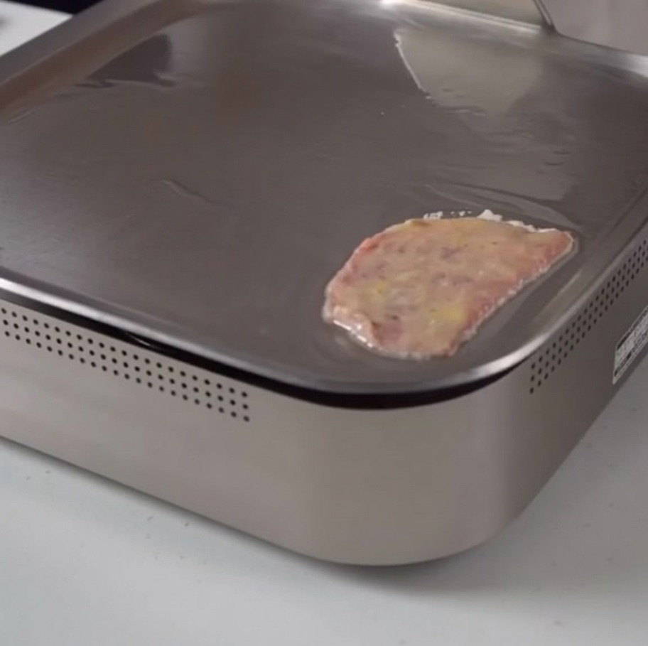 フライパンで焼かれている卵をまとった牛肉スライス。