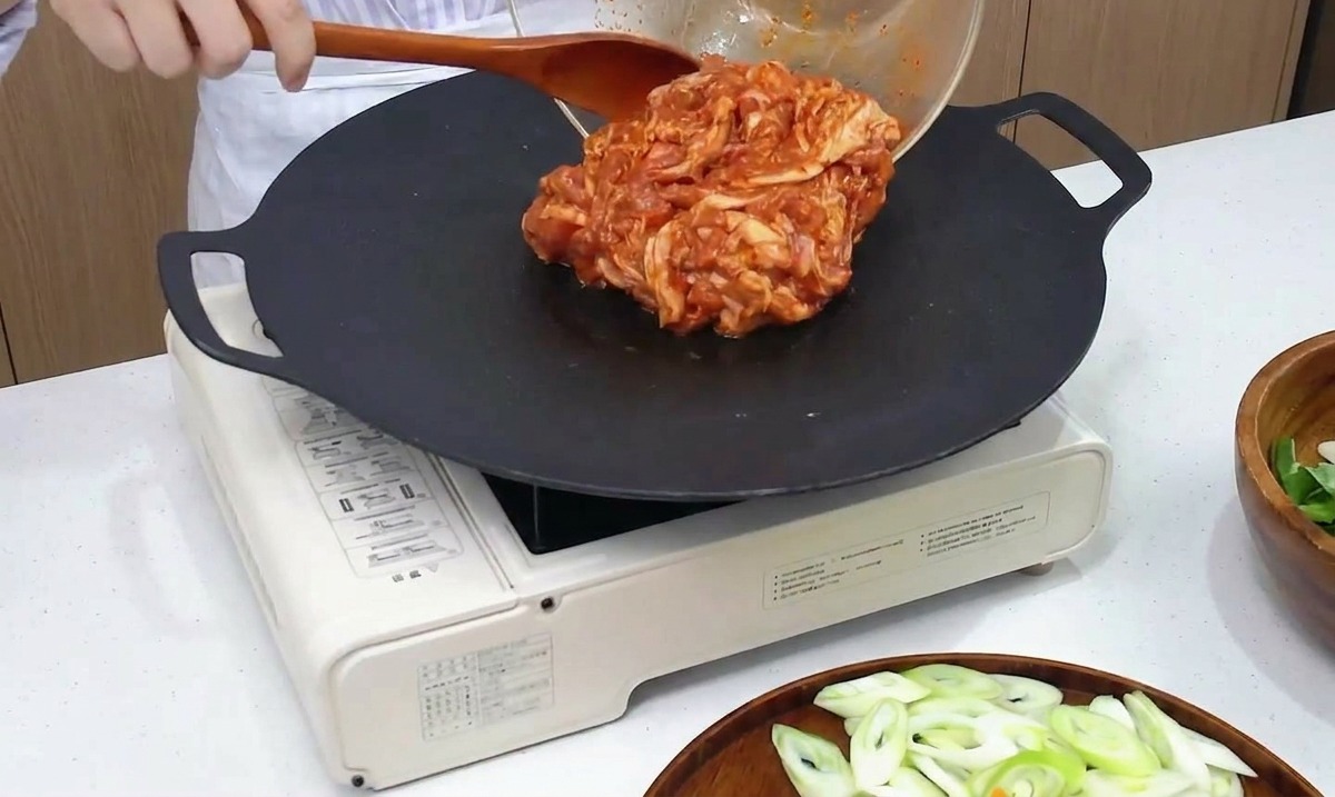 熱したフライパンに、マリネした豚肉を流し込んでいる様子。