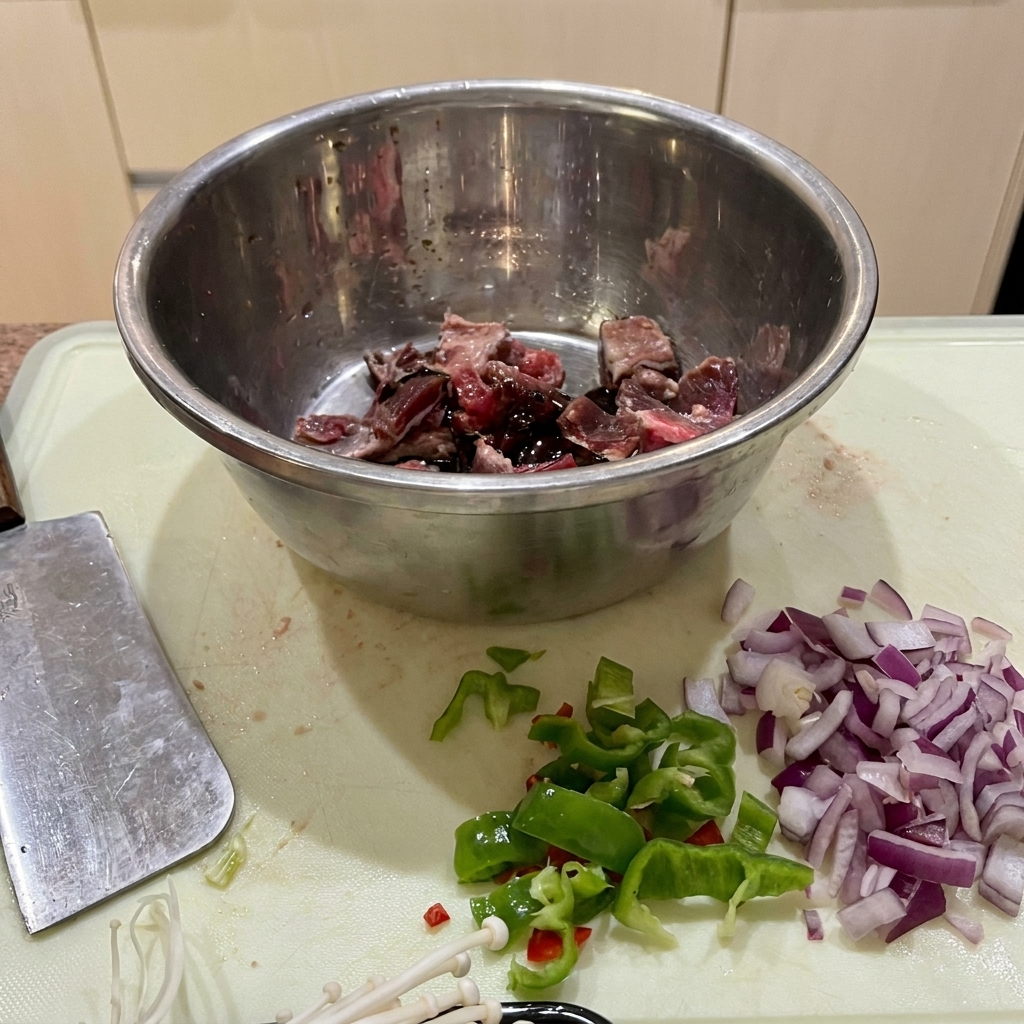 ボウルに入った牛肉に醤油、オイスターソース、片栗粉を加えて揉み込んでいる様子。