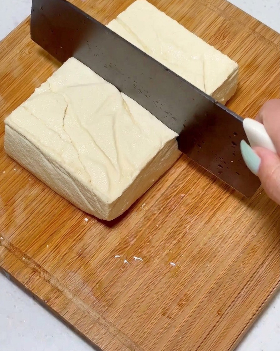 包丁を使って、木綿豆腐を同じくらいの大きさにカットしている様子。