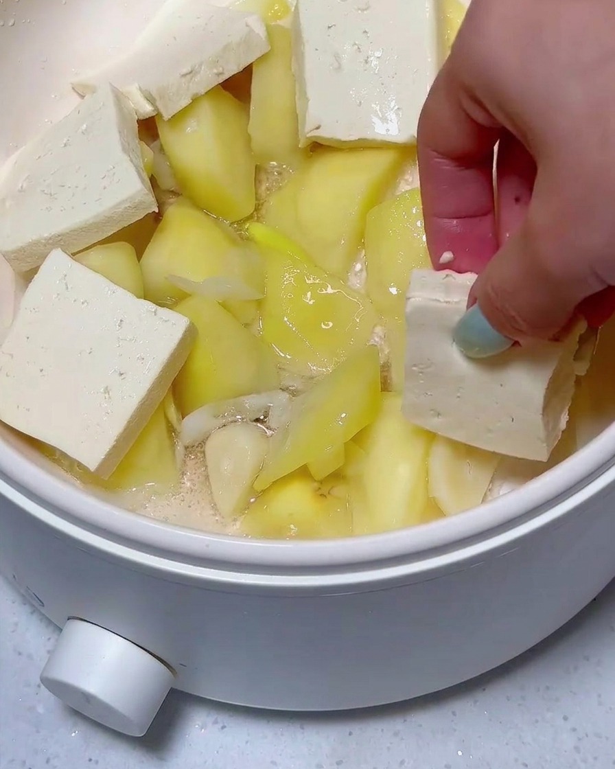 炒めたじゃがいもの上に、豆腐とスパムが整然と並べられている様子。