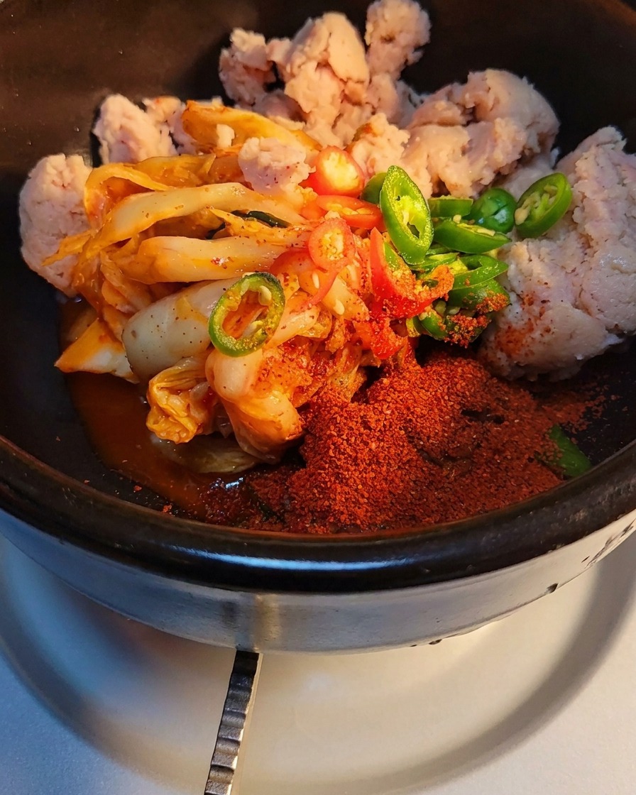 土鍋の具材に砂糖と牛肉粉末調味料を振りかけている様子。