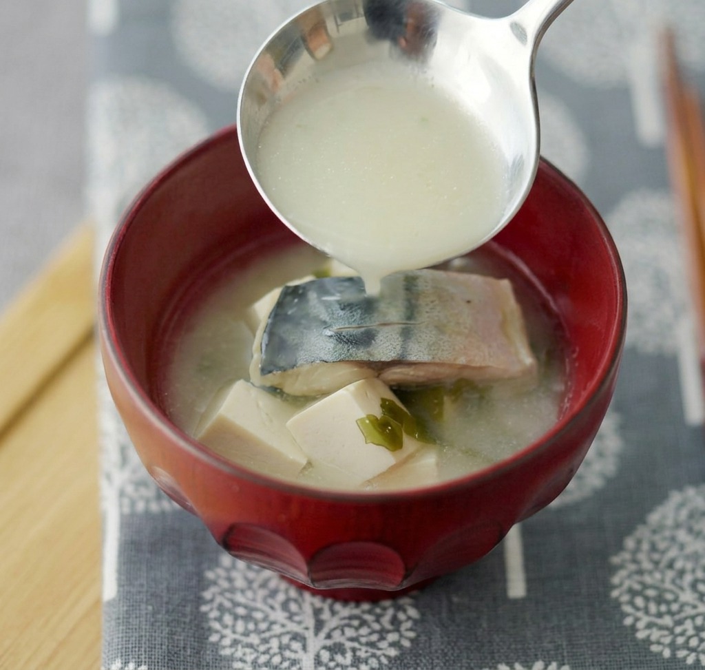 完成した味噌汁を器によそい、ネギを散らしている様子。